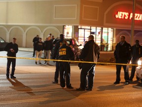 Police investigate a scene after a St. Louis police officer was shot in what the police chief called an "ambush" on Sunday, Nov. 20, 2016, in St. Louis. Police Chief Sam Dotson said the 46-year-old officer was shot in the face. (David Carson/St. Louis Post-Dispatch via AP)