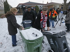 Scarborough resident Marcia Stiles has help from Councillor Michael Thompson and Mayor John Tory as he announced that he would pursue contracted-out garbage on the east side of the city on Monday, November 21, 2016. (Michael Peake/Toronto Sun)