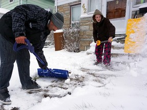 Luke Hendry/The Intelligencer
George Johnson and Sammy Maracle shovel snow on Chatham Street in Belleville Monday. The first winter storm of the season brought drifting, heavy snow to the city. City police reported with 22 collisions between 5 a.m. Sunday and 5 a.m. Monday.