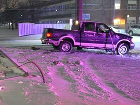Submitted Photo/Kingston Police
A Kingston Police photo shows a pickup truck resting against a utility pole after taking out a light standard in front of Frontenac Secondary School on Sunday. The driver was arrested for impaired driving.