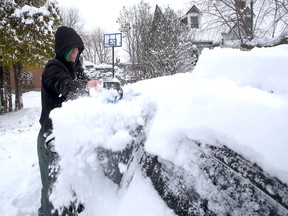Emmett Mader cleans off his car on Montreal Street during an early season snow storm in Kingston prior to going to work at the Division Street Canadian Tire store on Monday November 21 2016. Ian MacAlpine /The Whig-Standard/Postmedia Network
