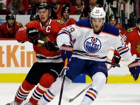 Edmonton Oilers center Leon Draisaitl, right, controls the puck against Chicago Blackhawks center Jonathan Toews during the first period of an NHL hockey game, Thursday, Dec. 17, 2015, in Chicago. (AP Photo/Nam Y. Huh)