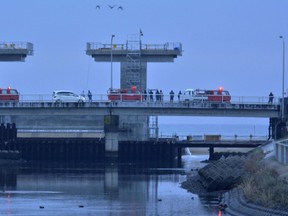 Firefighters and city officials check the water level at an estuary following a tsunami warning in Iwaki, Fukushima prefecture, early Tuesday, Nov. 22, 2016. Coastal residents in Japan were ordered to flee to higher ground on Tuesday after a strong earthquake struck off the coast of Fukushima prefecture. (Kyodo News via AP)