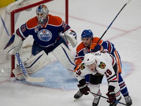 Kris Russell pushes Blackhawks captainJonathan Toews out of goalie Cam Talbot way during the first period of Monday's game at Rogers Place. (Greg Southam)