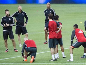 Toronto FC head coach Greg Vanney (left) talks to his players during a training session at Olympic Stadium in Montreal yesterday. (THE CANADIAN PRESS)