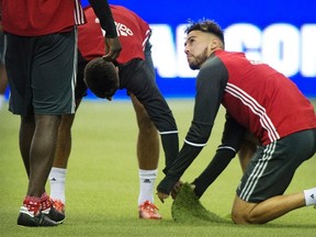 TFC's Jonathan Osorio examines the turf at Olympic Stadium in Montreal on Monday. (THE CANADIAN PRES)