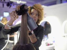 A  Dyson representative styles a model during the Dyson Supersonic Hair Dryer launch event at Center548 on September 14, 2016 in New York City.  (Photo by Jason Kempin/Getty Images for Dyson)