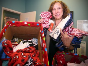 Suzanne Stitt displays some of the pyjamas donated for the 2016 PJ Drive sponsored by the Manitoba Chiropractic Association. (Brian Donogh/Winnipeg Sun)