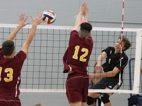 Arie Moffatt of the Kingston Blues has his spike blocked by Regiopolis Notre-Dame Panthers Piers Elms, left, and Dylan Medeiros during the Kingston Area Secondary Schools Athletic Association senior volleyball final at the Queen's Athletics and Recreation Centre on Nov. 13. (Steph Crosier/The Whig-Standard)