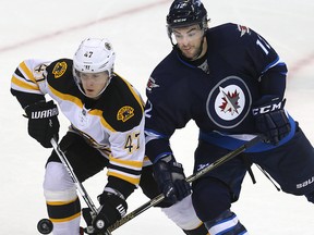 Boston Bruins defenceman Torey Krug (left) and Winnipeg Jets right winger Drew Stafford battle for control of the puck during a game last month. Stafford is expected to return to the Jets' lineup on Wednesday. (Brian Donogh/Winnipeg Sun file photo)