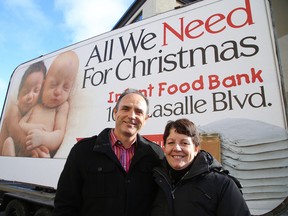 Petryna Advertising president David Petryna (left) and Infant Food Bank executive director Dedee Flietstra pose alongside a billboard to launch the All We Need for Christmas campaign in Sudbury on Tuesday, Nov. 22, 2016. Gino Donato/The Sudbury Star/Postmedia Network
