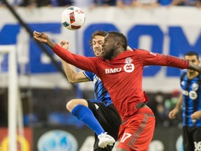 Toronto FC’s Jozy Altidore fights for the ball with a Montreal Impact player during last night’s game. (THE CANADIAN PRESS)