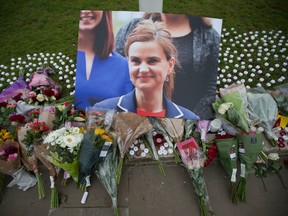 This is a Friday, June 17, 2016, file photo of an image and floral tributes for Jo Cox, in Parliament Square, outside the House of Parliament in London, after the 41-year-old British Member of Parliament was fatally injured in northern England. A jury Wednesday Nov. 23, 2016, found Thomas Mair with white supremacist views guilty of murdering Labour lawmaker Jo Cox a week before Britain's EU membership referendum. (AP Photo/Matt Dunham, File)