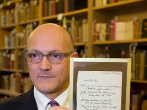 Thijs Blankevoort, director of Bubb Kuyper auction house, holds a short poem by Anne Frank, handwritten and dated in Amsterdam on March 28, 1942, prior to the auction in Haarlem, Netherlands, Wednesday, Nov. 23, 2016. (AP Photo/Peter Dejong)