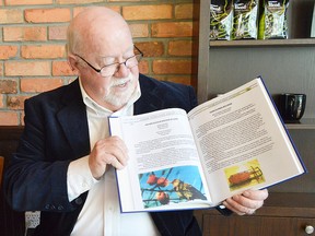 Local author Fred Osmon turns to a page in his new book, Chatham 'N' Kent's Heroes. The book looks at one hero every year, pulled from stories and newspaper clippings and collected in the 132-page hardcover book.