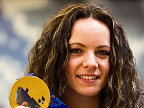 Shannon Szabados, goaltender for the gold medal-winning Canadian women's ice hockey team, poses with her gold medal at the Edmonton International Airport in Leduc, Alta., on Feb. 25, 2014. (Codie McLachlan/Edmonton Sun)