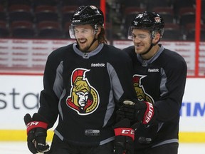 Senators captain Erik Karlsson (left), wearing Dion Phaneuf’s slightly bigger equipment on a day off for the defenceman, puts a smile on the face of teammate Mark Borowiecki. (Tony Caldwell, Ottawa Sun)