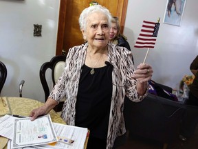 America Maria Hernandez, 99, holds an American flag after being administered the Naturalization Oath of Allegiance, Wednesday, Nov. 23, 2016 photo, in the Queens borough of New York.(AP Photo/Richard Drew)