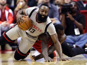 Rockets’ James Harden (left) falls to the court as Toronto Raptors’ Pascal Siakam tries to steal the ball in Houston Wednesday night. (AP)
