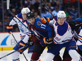 Avalanche right wing Rene Bourque battles for the puck with Jesse Puljujarvi and Milan Lucic during the first period of Wednesday's game in Denver. (AP Photo)