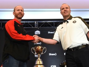 Stampeders coach Dave Dickenson and RedBlacks head coach Rick Campbell shake hands during the coaches availability in Toronto Wednesday in advance of Sunday's Grey Cup game. (The Canadian Press)