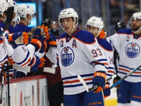 Edmonton Oilers center Ryan Nugent-Hopkins is congratulated as he passes the team box after scoring an unassisted goal against the Colorado Avalanche in the first period of an NHL hockey game, Wednesday, Nov. 23, 2016, in Denver. (AP Photo/David Zalubowski)