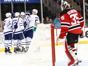 Toronto Maple Leafs players celebrate a goal by Auston Matthews against New Jersey Devils goalie Cory Schneider, right, during the first period of an NHL hockey game, Wednesday, Nov. 23, 2016, in Newark, N.J. (AP Photo/Julio Cortez)