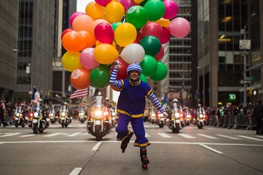 A performer carries balloons across Sixth Avenue during the Macy's Thanksgiving Day Parade, in New York, Thursday, Nov. 24, 2016. (AP Photo/Andres Kudacki)
