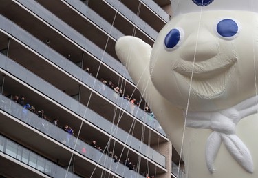 Spectators watch from balconies along Central Park South as the Pillsbury Doughboy balloon passes during the Macy's Thanksgiving Day parade, Thursday, Nov. 24, 2016, in New York. (AP Photo/Julie Jacobson)