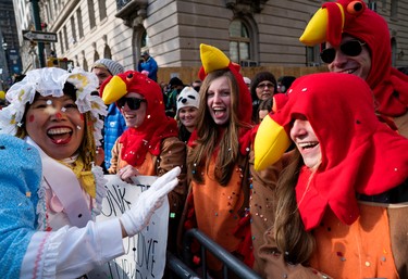A parade participant tosses confetti on, from center left, Annie Quinn, Lauren Quinn, Mark Rossman and Abby Quinn, all of Albany, New York, during the Macy's Thanksgiving Day Parade in New York Thursday, Nov. 24, 2016. The Quinns are sisters and Rossman is their cousin. (AP Photo/Craig Ruttle)