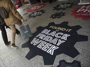 Shoppers walk past a sign for Black Friday deals outside a department store on Oxford Street on November 22, 2016 in London, England. (Jack Taylor/Getty Images)