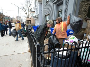 London?s municipal bylaw chief Orest Katolyk, back left, talks with landlord Erwin Daw outside his Dundas Street rental property as city workers Emily McLachlan, Zach Parkins and Ed Japp remove garbage from the front of the house after complaints about neglected trash led to two separate fines this week. (CRAIG GLOVER, The London Free Press)