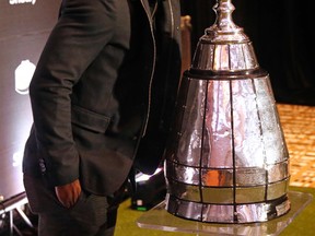 Redblacks defensive back Jerrell Gavins makes sure not to touch the Grey Cup yesterday at a news conference in Toronto. (Michael Peake, Postmedia Network)