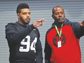 Redblacks defensive tackle Cleyon Laing (left) talks things over with and Leroy Blugh, the team’s defensive line coach. Blugh says his unit is capable of controlling the Stampeders’ high-octane offence if his players stick to the game plan and execute. Laing’s responsibility will be stopping Calgary running back Jerome Messam. (Postmedia files)