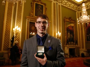 Tyler Bailer holds the Russell medal after being presented with it by Britain's Queen Elizabeth II at a ceremony at Buckingham Palace in London, Tuesday, Nov. 22, 2016. AP Photo/Alastair Grant