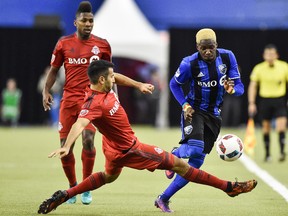 Steven Beitashour of Toronto FC (centre) defends the ball against Ambroise Oyongo (right) of the Impact during the first leg of the East final. The second leg goes Wednesday in Toronto. (Getty Images)