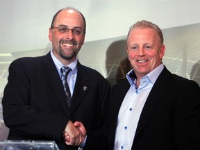 Marcel Desjardins shakes hands with RedBlacks owners group president Jeff Hunt when he is named the team's GM in January 2013. (The Canadian Press)