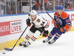 Matt Benning, shown here checking Blackhawks forward Tyler Motte, has taken advantage of his opportunity to play with the Oilers this season. (The Canadian Press)