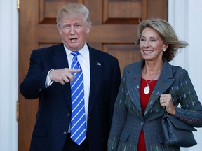 In this Nov. 19, 2016 file photo, President-elect Donald Trump and Betsy DeVos pose for photographs at Trump National Golf Club Bedminster clubhouse in Bedminster, N.J. Trump has chosen charter school advocate DeVos as Education Secretary in his administration. (AP Photo/Carolyn Kaster, File)