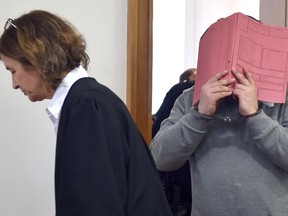 German former male nurse Niels H hides his face behind a folder as he waits next to his lawyer Ulrike Baumann (L) for the opening of another session of his trial on February 26, 2015 at court in Oldenburg, northwestern Germany. (CARMEN JASPERSEN/AFP/Getty Images)