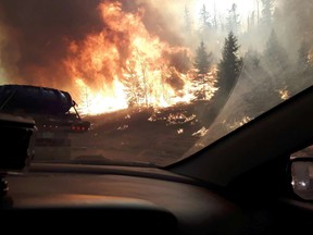 Flames lick the southbound side of Highway 63 as a destructive wildfire forced thousands of people to leave Fort McMurray, Alta. on Tuesday May 3, 2016. Robert Murray/Fort McMurray Today/Postmedia Network