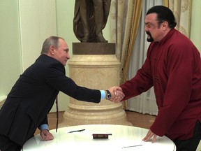 Russian President Vladimir Putin shakes hands with U.S. actor Steven Seagal in the Kremlin in Moscow,Friday, Nov. 25, 2016. Putin has given a Russian passport to Seagal, a regular visitor to Russia in recent years, calling it a sign of a thaw in relations between the two countries. (Alexei Druzhinin/Sputnik, Kremlin Pool Photo via AP)