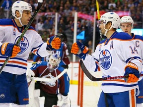 Jordan Eberle, centre, of the Edmonton Oilers is congratulated on his first period goal by Milan Lucic, left, and Connor McDavid against the Colorado Avalanche at Pepsi Center on November 23, 2016 in Denver, Colorado.