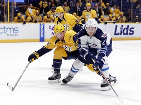 Winnipeg Jets right wing Nikolaj Ehlers (27), of Denmark, reaches for the puck as he is defended by Nashville Predators' Matt Irwin (52) during the first period of an NHL hockey game Friday, Nov. 25, 2016, in Nashville, Tenn. (AP Photo/Mark Humphrey