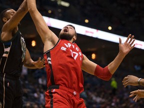 Raptors' Jonas Valanciunas (17) reaches for a rebound against the Bucks' Jabari Parker during first half NBA action in Milwaukee on Friday, Nov. 25, 2016. (Jeffrey Phelps/AP Photo)