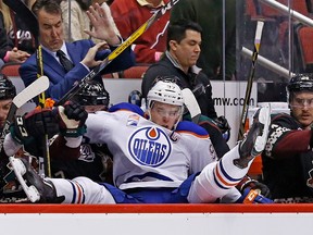 Edmonton Oilers center Connor McDavid ends up over the boards and into the Arizona Coyotes bench during the second period of an NHL hockey game Friday, Nov. 25, 2016, in Glendale, Ariz.