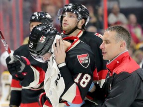 Blood can be seen running down Ryan Dzingel's face as he is taken off the ice by the Senators head athletic therapist Gerry Townsend in the first period of Ottawa's game against the Boston Bruins at Canadian Tire Centre in Ottawa on Thursday, Nov. 24, 2016. Julie Oliver/Postmedia