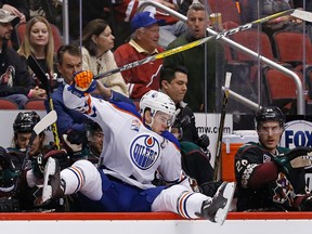 Edmonton Oilers center Connor McDavid leaps into the Arizona Coyotes bench area during the second period of an NHL hockey game Friday, Nov. 25, 2016, in Glendale, Ariz. (AP Photo/Ross D. Franklin)