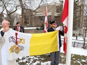 Deacon Roland Muzzatti, left, and Kerry Leach, of Branch 76 of the Royal Canadian Legion, take part in a flag-raising ceremony at the launch of 100th anniversary celebrations at the Church of Christ the King in Sudbury, Ont. on Saturday November 26, 2016. The church is celebrating the anniversary which coincides with Canada's 150th anniversary in 2017. John Lappa/Sudbury Star/Postmedia Network