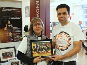 Angelica Sanchez-Castaleda, left, and Marco Salinas-Garcia, right, hold a picture of their daughter Fernanda Salinas-Sanchez and her basketball team, the Westminster Warriors, during a tournament at Westminster School at 13712 104 Ave. in Edmonton on Nov. 26, 2016. Fernanda, 16, was kiled in a car accident on July 25, 2016, in Mexico while visiting family. CLAIRE THEOBALD Postmedia